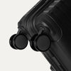 Black suitcase with wheels on a light gray background