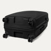 Underside view of the Optima Expandable Large Check-in Spinner in Black, showcasing the durable base and self-aligning PrecisionGlide spinner wheels designed for smooth, effortless mobility.